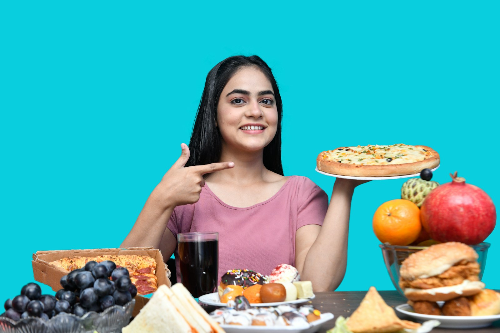 a woman sitting at a table with food and drinks